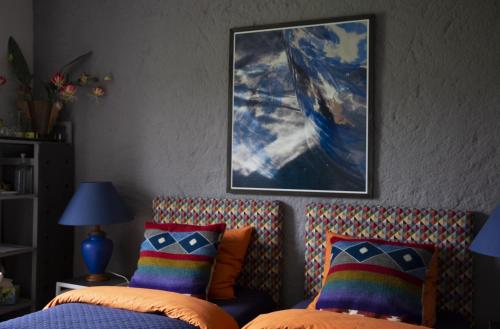 Locmaria-BerrienLa Colline des Renards Chambres的一间卧室设有两张床,墙上挂着一幅画