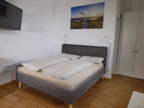 班贝格Pretti Apartments - NEUES stilvoll eingerichtetes Apartment im Zentrum von Bamberg的带平面电视的客房内的一张床位