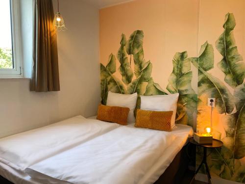 奈梅亨信诚酒店的墙上挂着植物壁画的房间里一张床位