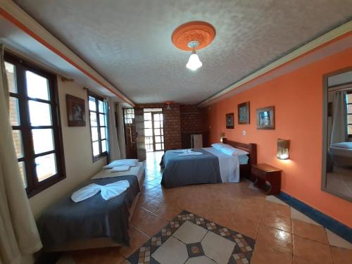 雅克南Hotel Pousada Viking的配有橙色墙壁和窗户的客房内的两张床
