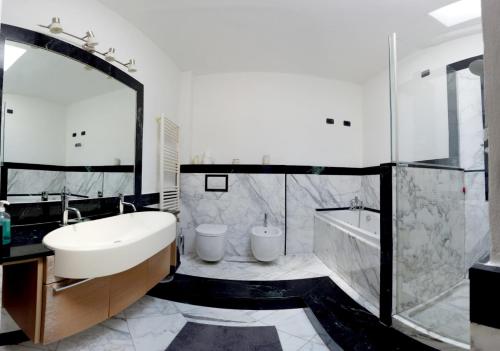 卡拉拉STUPENDA MANSARDA CENTRALISSIMA, finiture di lusso的一间带水槽、浴缸和卫生间的浴室