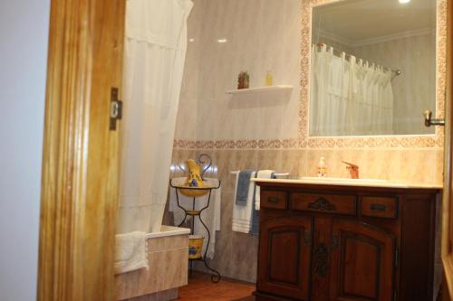因凡特斯新镇CASA RURAL BUENA VENTURA的带浴缸、水槽和镜子的浴室