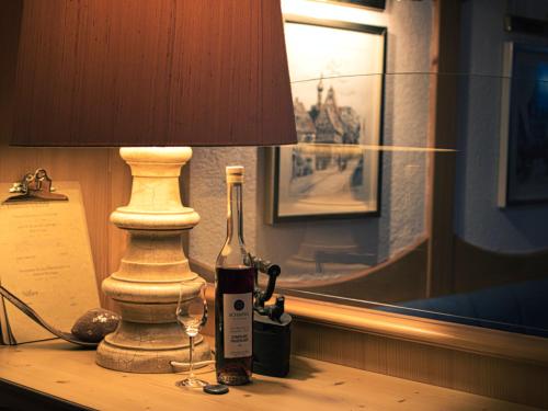 巴特温普芬Neckarblick SELF Check IN Hotel的一瓶葡萄酒和一张桌子上的灯
