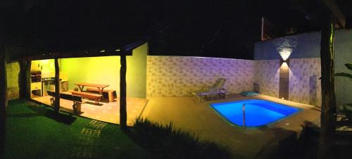博尼图RANCHO DA PISCINA EM BONITO的一座晚上设有游泳池的房子