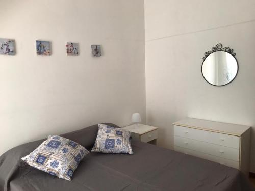 托雷坎内Appartamento Stella Maris的卧室配有一张床,墙上设有镜子