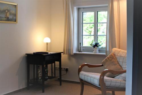 尼布卢姆Föhrer Friesenkate Ost的客房设有椅子、书桌和窗户。