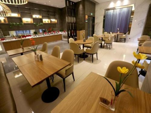 巴中锦江之星品尚巴中广福街酒店的餐厅设有木桌、椅子和柜台
