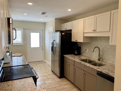 Point O'RocksIsland House Beach Resort 12S的厨房配有白色橱柜和不锈钢冰箱