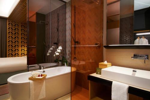 新加坡Oasia Hotel Downtown, Singapore by Far East Hospitality的带浴缸和盥洗盆的浴室