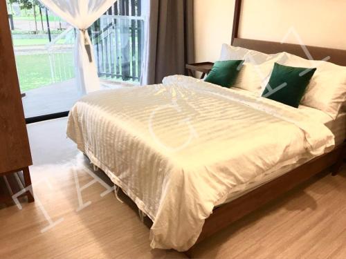 关丹TA-G-11 @timurbay的卧室内的一张带白色床单和绿色枕头的床