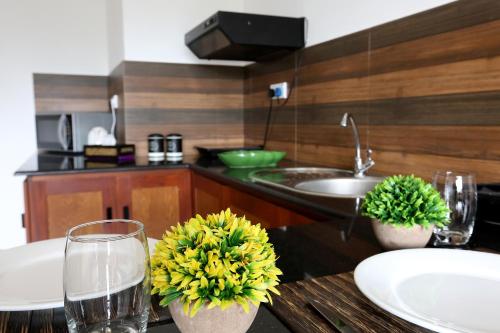 拉维尼亚山Iddamal Apartments的厨房配有带水杯和鲜花的桌子