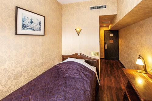 冈崎市冈崎大和酒店的一间卧室,在房间内配有一张紫色的床