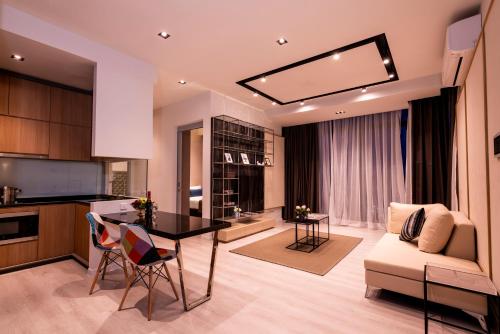吉隆坡ExpressionZ KLCC By Starwood Luxury的厨房以及带桌子和沙发的客厅。