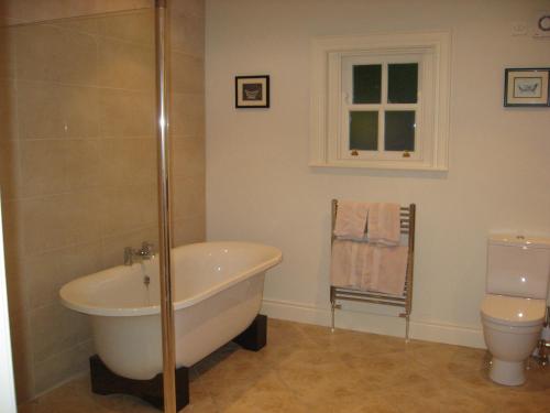 Irvinestown城堡景度假屋的带浴缸和卫生间的浴室。
