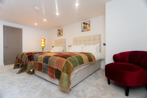 利兹Westwood Apartment的一间卧室配有一张大床和一张红色椅子