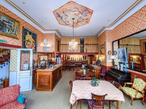 奥尔良德拉贝勒酒店的客厅配有桌子和钢琴