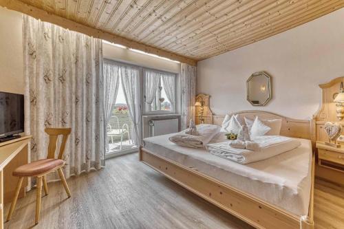 雷根Zum singenden Musikantenwirt的一间卧室设有一张大床和一个大窗户