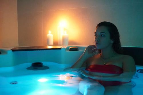 费托瓦亚Hotel Galli - Wellness & Spa的坐在带蜡烛的浴缸中的女人