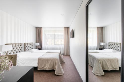克莱佩达克莱佩达艾伯顿酒店的酒店客房,设有两张床和镜子