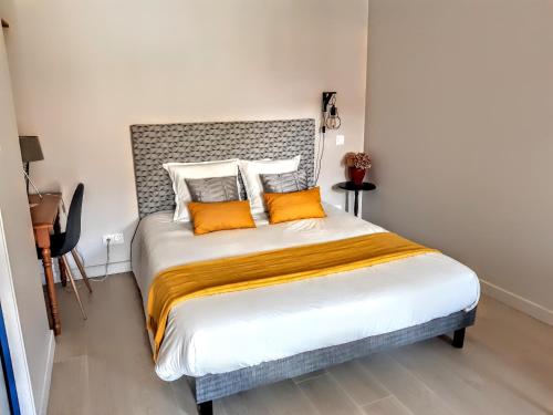 Chaux10 Côté Cour的一间卧室配有一张带橙色枕头的大床