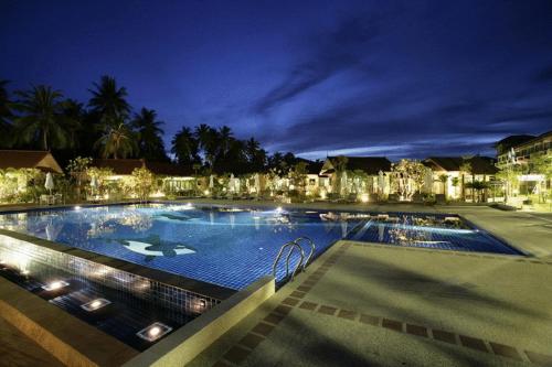 奎武里葵布度假酒店的夜间大型游泳池,灯光照亮