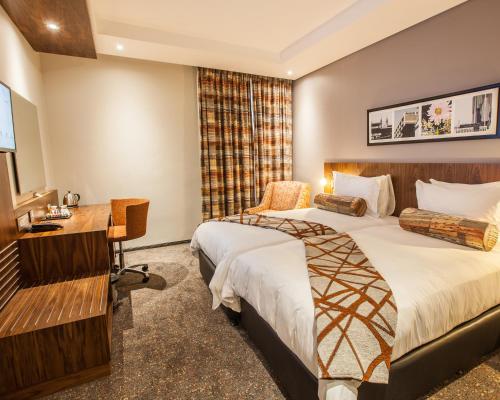 约翰内斯堡City Lodge Newtown, Johannesburg的酒店客房配有两张床和一张书桌