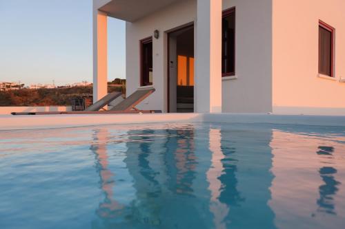 伊亚Aplada Suites的别墅毗邻一座房子,设有游泳池