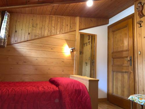 科尔蒂纳丹佩佐Attico Vista Tofane的一间卧室设有红色的床和木墙