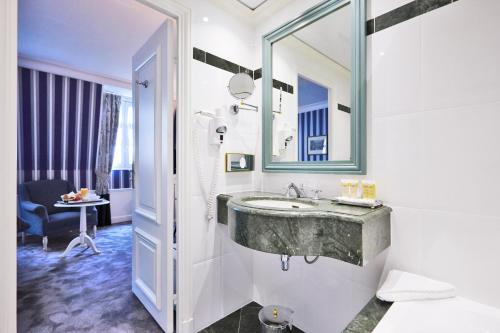 巴黎金色郁金香华盛顿剧院酒店的一间带水槽和镜子的浴室