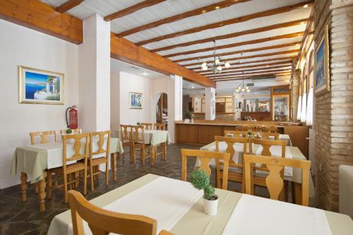 特尔斐Acropole Delphi City Hotel的一间带桌椅的餐厅和一间用餐室