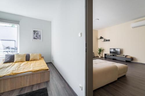 希欧福克City Home Balaton的一间卧室配有一张大床和电视