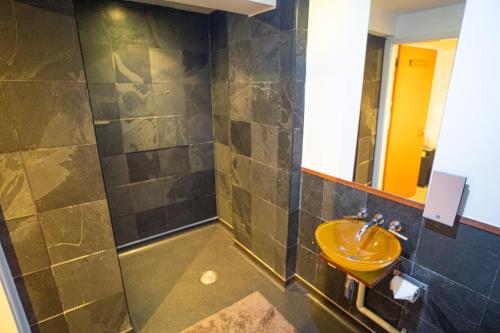布由德利皇家森林乡村酒店的浴室设有黄色水槽和镜子