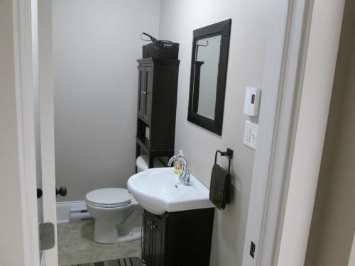 巴瑟斯特Executive Suites Bathurst的一间带水槽、卫生间和镜子的浴室