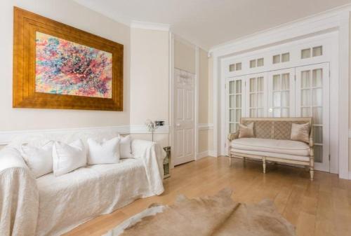 伦敦Marylebone Luxury Duplex的客厅配有白色的沙发和椅子