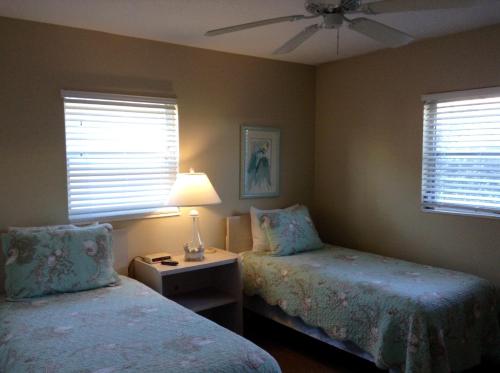 西耶斯塔岛Island House Beach Resort 10A的一间卧室配有两张床和一张带台灯的桌子