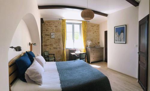 维特拉克Le Petit Manoir de Vitrac的一间卧室设有一张大床和一个窗户。
