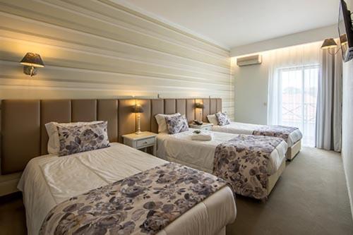 法蒂玛Hotel Alecrim的酒店客房设有两张床和窗户。