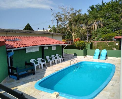 卡拉瓜塔图巴Condomínio Vila Gustavo -excelente localização的房屋旁带椅子的游泳池