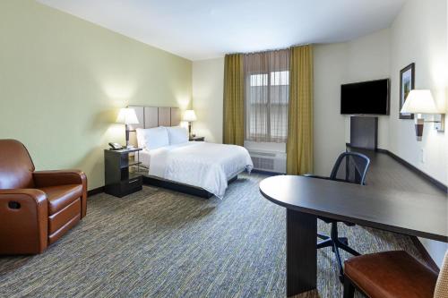 休斯顿Candlewood Suites Houston - Spring, an IHG Hotel的配有一张床和一张书桌的酒店客房