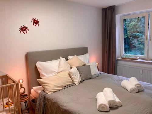 哈里斯莱Pier39 Ferienwohnung Wassersleben Flensburg的卧室配有带枕头的床铺和窗户。