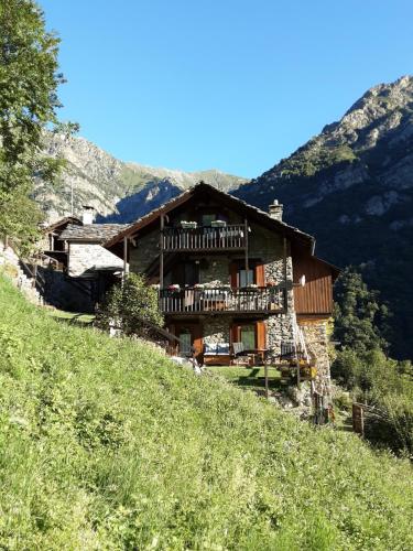 巴尔德马奇林娜住宿加早餐旅馆的一座位于山丘上的大木房子,背景是群山