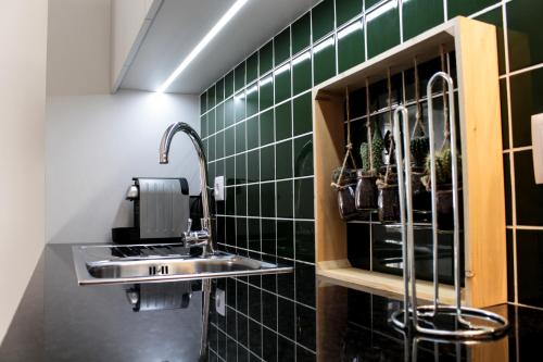 波尔图Casa Jardim By Alojamento Ideal的一间带水槽和绿色瓷砖墙壁的浴室