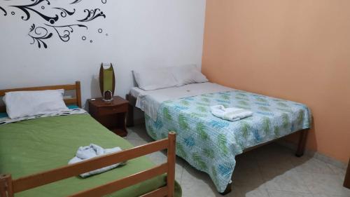 富萨加苏加Hotel Dorado Real的一间卧室配有两张带毛巾的床