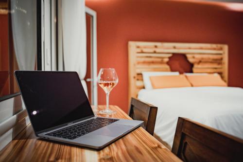 圣丹尼斯Le Terracotta - Appartement privatif的一张桌子上的笔记本电脑,边喝一杯葡萄酒
