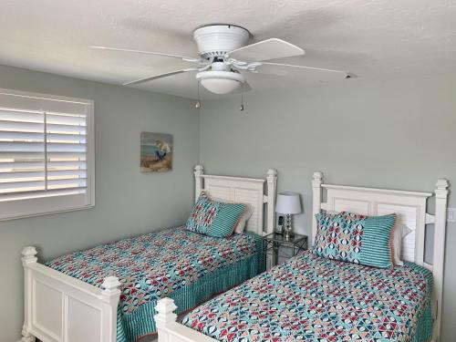 西耶斯塔岛Island House Beach Resort 7的一间卧室配有两张床和吊扇