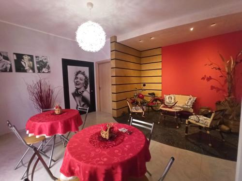 夏卡B&B Omer的一间房间,设有两张桌子和红色桌布