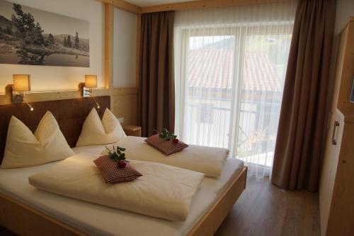 盖洛斯Haus Dorfblick的酒店客房设有两张床和大窗户。