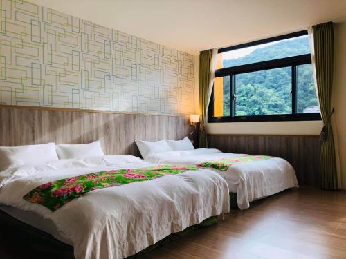 南庄乡南庄漫晨旅店Nanzhuang Manchen B&B的带大窗户的客房内的两张床
