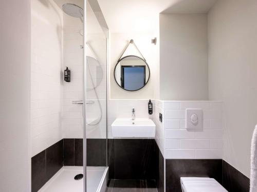 拉罗谢尔拉罗谢尔老港宜必思酒店的带淋浴、盥洗盆和镜子的浴室