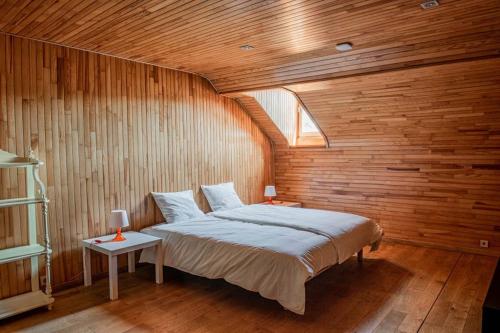 普罗丰德维耶Les Hauts de Meuse的卧室配有一张木墙内的大床